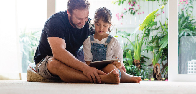 image of father reading a book with his daughter