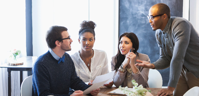 Four people discussing business in an office setting