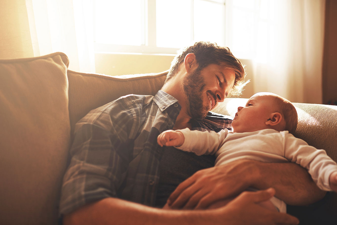 father smiling looking at his baby